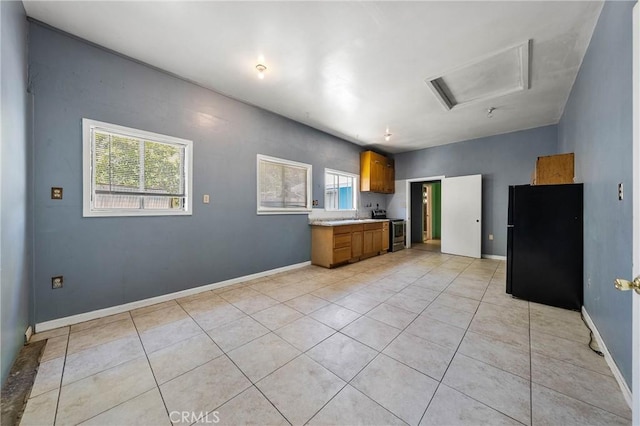 16374 35th Ave Unit 2, Clearlake, CA 95422 - kitchen with freestanding refrigerator, brown cabinets, light countertops, and light tile patterned floors