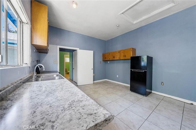 16374 35th Ave Unit 2, Clearlake, CA 95422 - kitchen with freestanding refrigerator, light tile patterned flooring, brown cabinetry, and light countertops