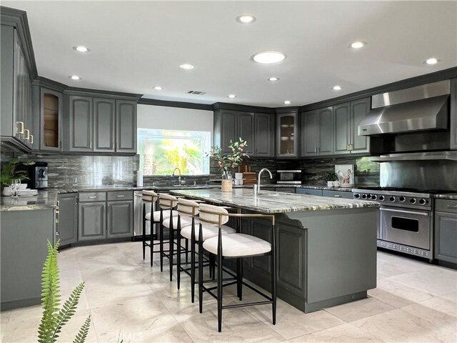 16815 Bajio Rd, Encino, CA 91436 - kitchen with double oven range, wall chimney range hood, stone countertops, tasteful backsplash, and recessed lighting