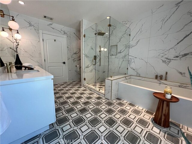 16815 Bajio Rd, Encino, CA 91436 - full bathroom featuring tile walls, a freestanding tub, a marble finish shower, vanity, and tile patterned floors