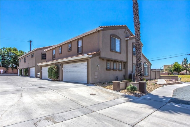 25545 Prospect Ave, Loma Linda, CA 92354 - view of home's exterior featuring a garage, driveway, stucco siding, and a tiled roof