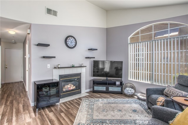 25545 Prospect Ave, Loma Linda, CA 92354 - living room featuring high vaulted ceiling, wood finished floors, a tile fireplace, and healthy amount of natural light