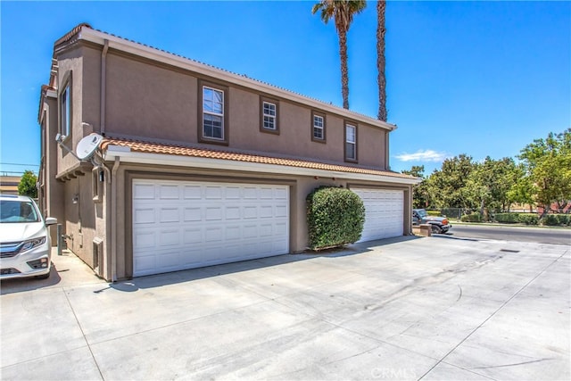 25545 Prospect Ave, Loma Linda, CA 92354 - view of front of house featuring driveway, an attached garage, stucco siding, and a tiled roof