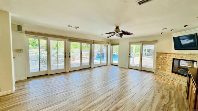 15696 Oakstand Rd, Poway, CA 92064 - unfurnished living room featuring crown molding, a ceiling fan, light wood-style flooring, a stone fireplace, and french doors
