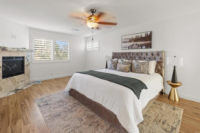 15696 Oakstand Rd, Poway, CA 92064 - bedroom featuring wood finished floors, a tiled fireplace, and ceiling fan