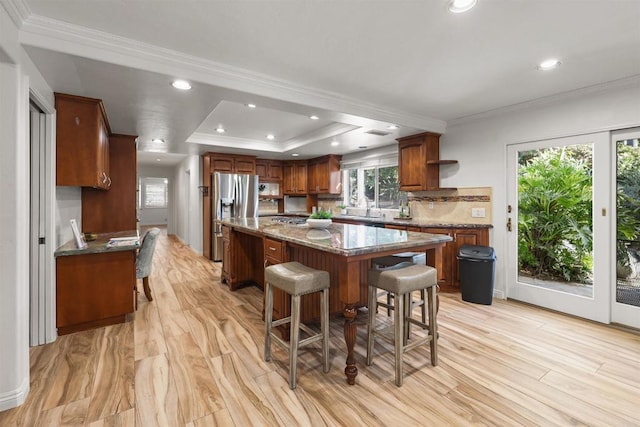 15696 Oakstand Rd, Poway, CA 92064 - kitchen with stainless steel refrigerator with ice dispenser, a kitchen island, a breakfast bar, ornamental molding, and a raised ceiling