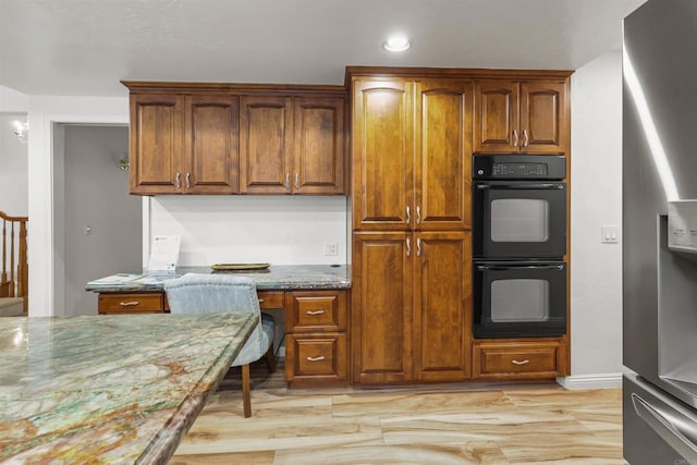 15696 Oakstand Rd, Poway, CA 92064 - kitchen featuring stainless steel fridge, built in desk, light wood-style floors, stone countertops, and brown cabinetry