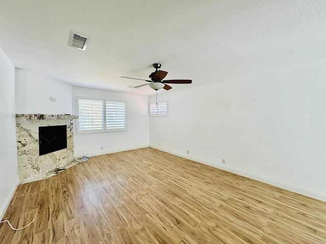 15696 Oakstand Rd, Poway, CA 92064 - unfurnished living room featuring light wood-style floors, a ceiling fan, and a premium fireplace