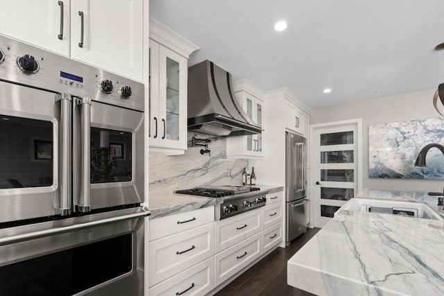 7133 Linden, Carlsbad, CA 92011 - kitchen featuring custom range hood, stainless steel appliances, white cabinetry, glass insert cabinets, and light stone counters