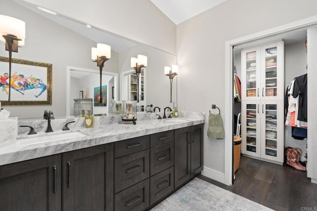 7133 Linden, Carlsbad, CA 92011 - bathroom with double vanity, wood finished floors, a walk in closet, and vaulted ceiling