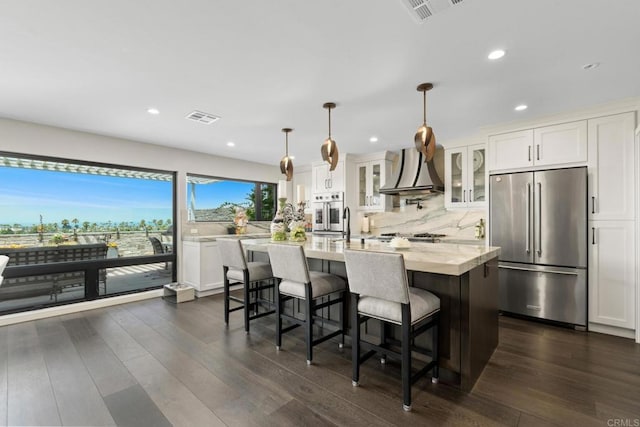 7133 Linden, Carlsbad, CA 92011 - kitchen featuring appliances with stainless steel finishes, wall chimney exhaust hood, glass insert cabinets, dark wood finished floors, and recessed lighting