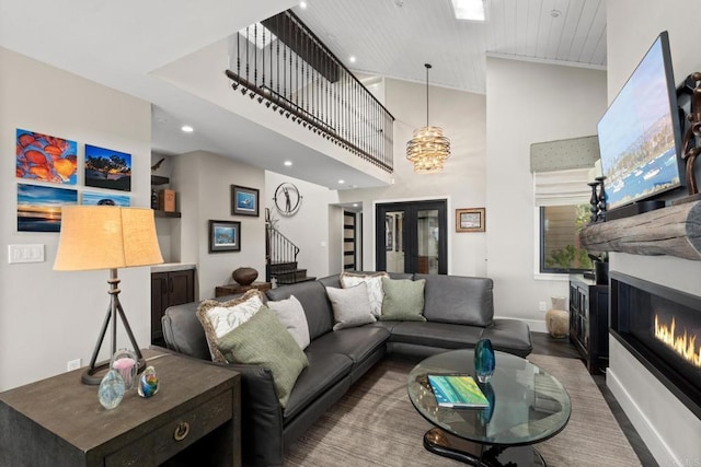 7133 Linden, Carlsbad, CA 92011 - living room with stairway, a glass covered fireplace, wood finished floors, recessed lighting, and a high ceiling