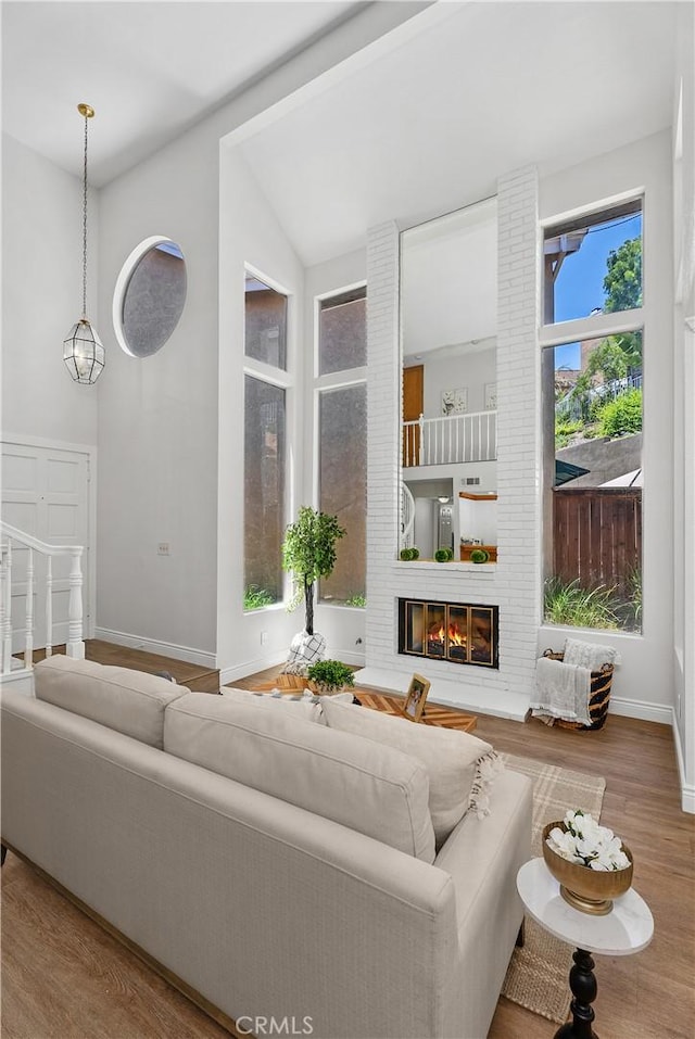 34 Carmel Ct, Laguna Beach, CA 92651 - living room featuring wood finished floors, a brick fireplace, and lofted ceiling