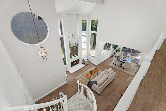 34 Carmel Ct, Laguna Beach, CA 92651 - living area featuring high vaulted ceiling, wood finished floors, and a fireplace