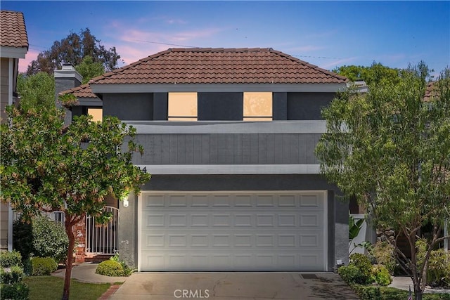 34 Carmel Ct, Laguna Beach, CA 92651 - view of front of house with a tiled roof, stucco siding, concrete driveway, and a garage