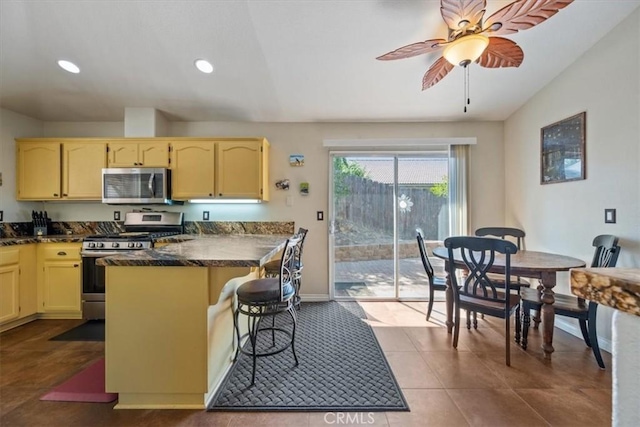 935 Running Stag Way, Paso Robles, CA 93446 - kitchen with appliances with stainless steel finishes, a kitchen breakfast bar, recessed lighting, a ceiling fan, and a peninsula