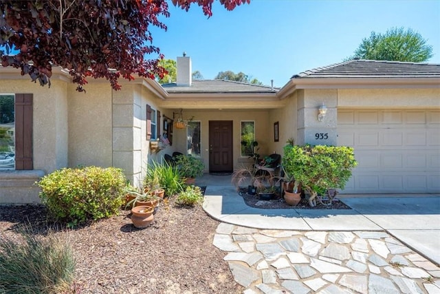 935 Running Stag Way, Paso Robles, CA 93446 - view of exterior entry featuring a chimney, a garage, stucco siding, concrete driveway, and a tiled roof