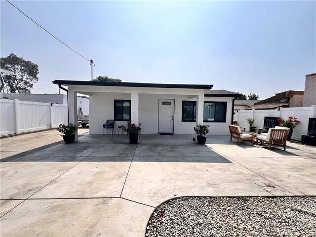 326 S Mcbride Ave, Los Angeles, CA 90022 - rear view of house featuring a patio, stucco siding, and outdoor lounge area