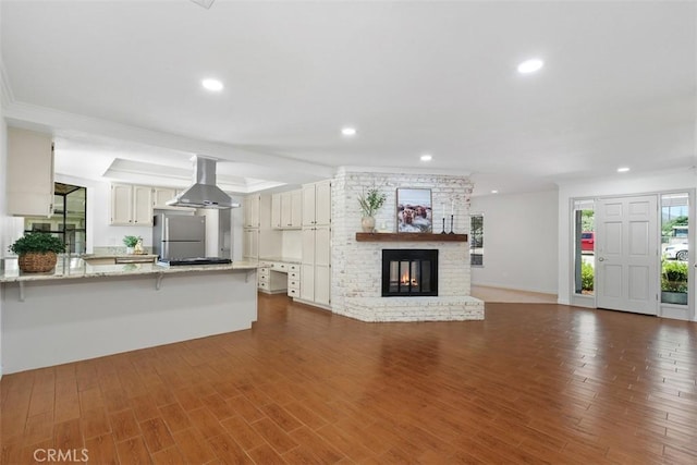 21285 Shoemaker Ln, Wildomar, CA 92595 - unfurnished living room with recessed lighting, a brick fireplace, dark wood-style flooring, and crown molding