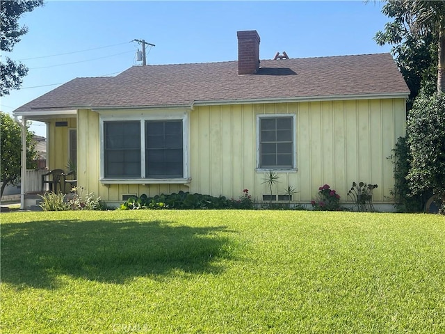 1654 Jess St, Pomona, CA 91766 - back of property featuring a chimney, a yard, roof with shingles, and board and batten siding