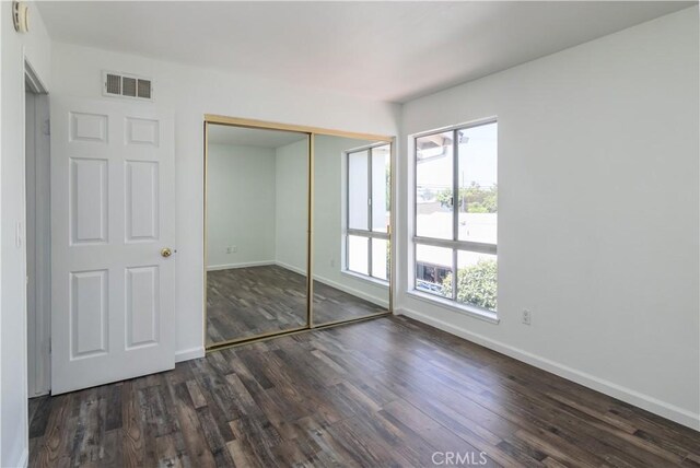 16755 Parthenia St Unit 5, Northridge, CA 91343 - unfurnished bedroom with multiple windows, dark wood finished floors, and a closet