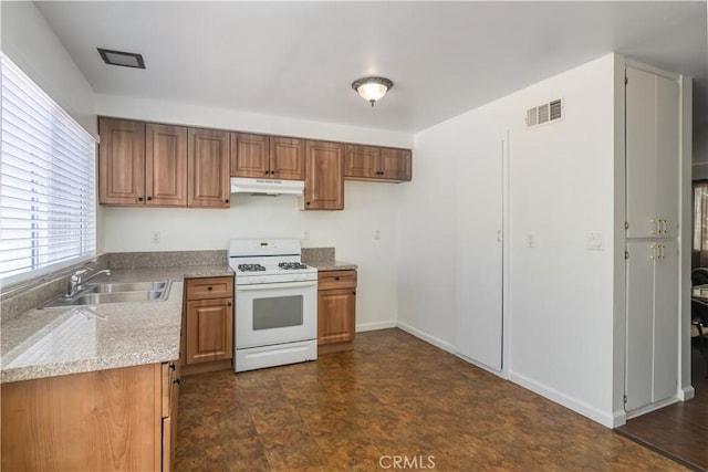 16755 Parthenia St Unit 5, Northridge, CA 91343 - kitchen with white gas range, under cabinet range hood, light countertops, and brown cabinetry