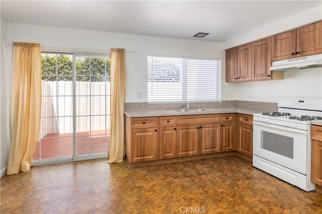 16755 Parthenia St Unit 5, Northridge, CA 91343 - kitchen with white range with gas stovetop, under cabinet range hood, light countertops, and brown cabinetry
