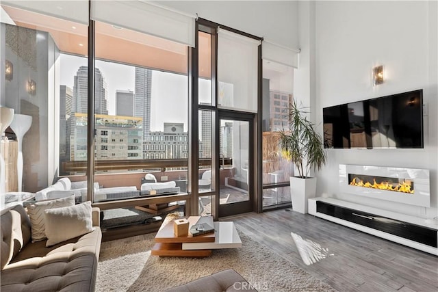 1100 Wilshire Blvd Unit 1707, Los Angeles, CA 90017 - living room featuring wood finished floors, a glass covered fireplace, and a wall of windows