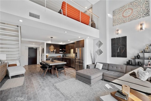 1100 Wilshire Blvd Unit 1707, Los Angeles, CA 90017 - living area featuring light wood-style flooring, a towering ceiling, and recessed lighting