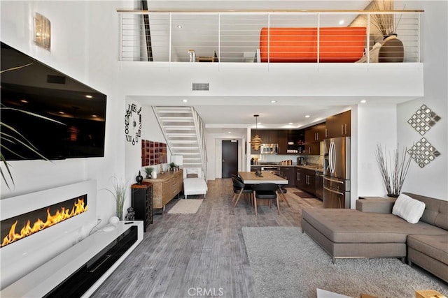 1100 Wilshire Blvd Unit 1707, Los Angeles, CA 90017 - living room featuring a high ceiling, wood finished floors, recessed lighting, and a lit fireplace