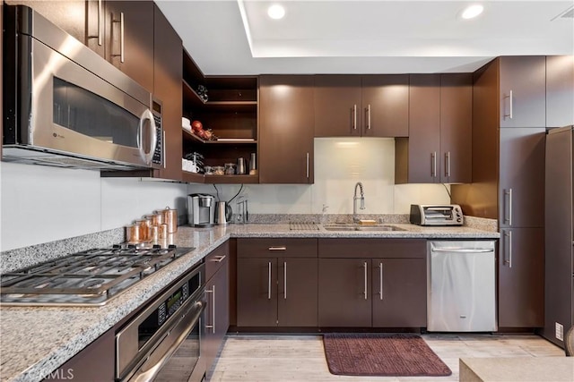 1100 Wilshire Blvd Unit 1707, Los Angeles, CA 90017 - kitchen with stainless steel appliances, recessed lighting, light wood-type flooring, light stone counters, and dark brown cabinetry