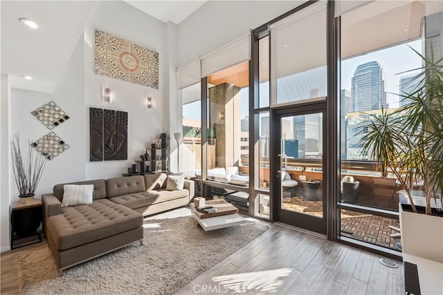 1100 Wilshire Blvd Unit 1707, Los Angeles, CA 90017 - living room with wood finished floors, a high ceiling, a city view, and a wall of windows