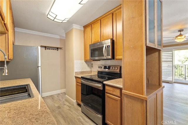 1710 S El Camino Real Unit E204, Encinitas, CA 92024 - kitchen featuring stainless steel appliances, crown molding, light wood finished floors, light countertops, and ceiling fan