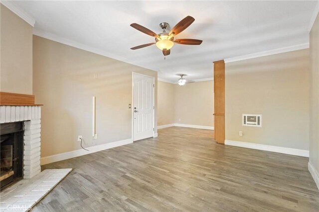 1710 S El Camino Real Unit E204, Encinitas, CA 92024 - unfurnished living room featuring ornamental molding, a fireplace, a ceiling fan, and wood finished floors
