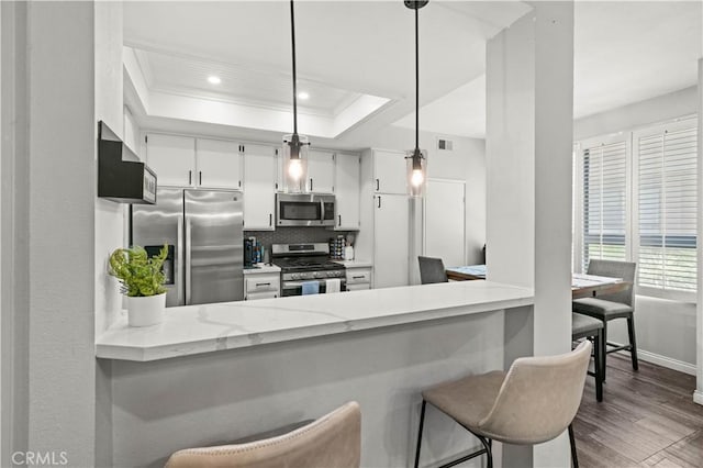 5722 E Stillwater Ave Unit 104, Orange, CA 92869 - kitchen featuring appliances with stainless steel finishes, dark wood-type flooring, a peninsula, tasteful backsplash, and white cabinetry