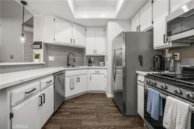 5722 E Stillwater Ave Unit 104, Orange, CA 92869 - kitchen featuring stainless steel appliances, crown molding, a tray ceiling, decorative backsplash, and white cabinets