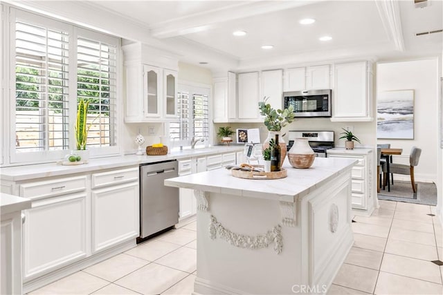 29813 Via Sevilla, Temecula, CA 92591 - kitchen with stainless steel appliances, light tile patterned flooring, a center island, white cabinets, and glass insert cabinets