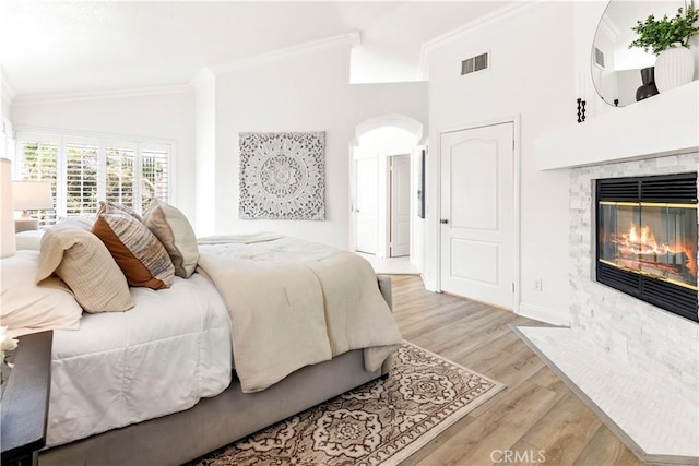 29813 Via Sevilla, Temecula, CA 92591 - bedroom with a fireplace with flush hearth, crown molding, light wood finished floors, vaulted ceiling, and arched walkways