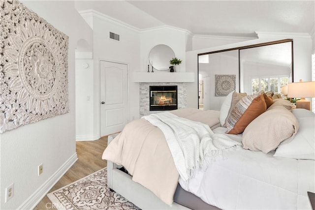 29813 Via Sevilla, Temecula, CA 92591 - bedroom with crown molding, light wood-style flooring, a fireplace, and lofted ceiling