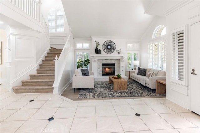 29813 Via Sevilla, Temecula, CA 92591 - tiled living area featuring high vaulted ceiling, healthy amount of natural light, stairs, ornamental molding, and a fireplace