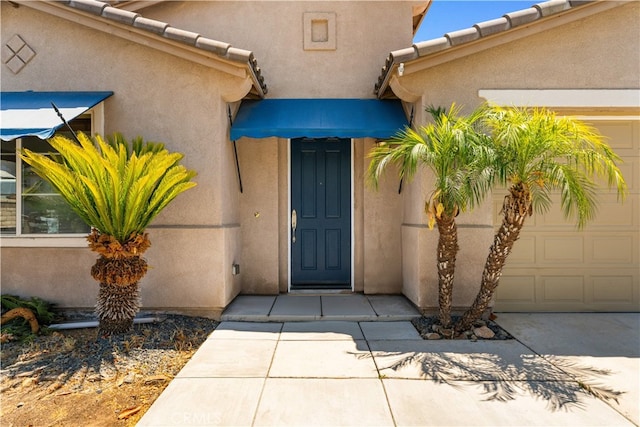 28677 Sunridge Ct, Menifee, CA 92584 - property entrance with an attached garage, stucco siding, and a tiled roof