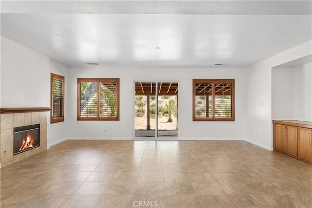 28677 Sunridge Ct, Menifee, CA 92584 - unfurnished living room featuring plenty of natural light, a tiled fireplace, and light tile patterned floors