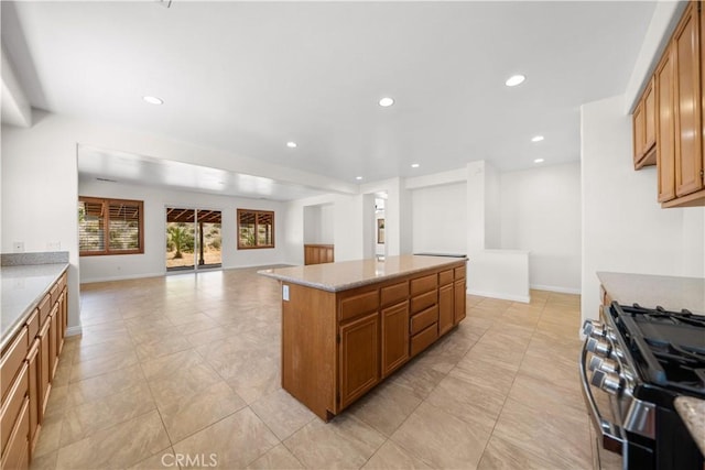 28677 Sunridge Ct, Menifee, CA 92584 - kitchen with open floor plan, recessed lighting, gas stove, brown cabinetry, and a center island