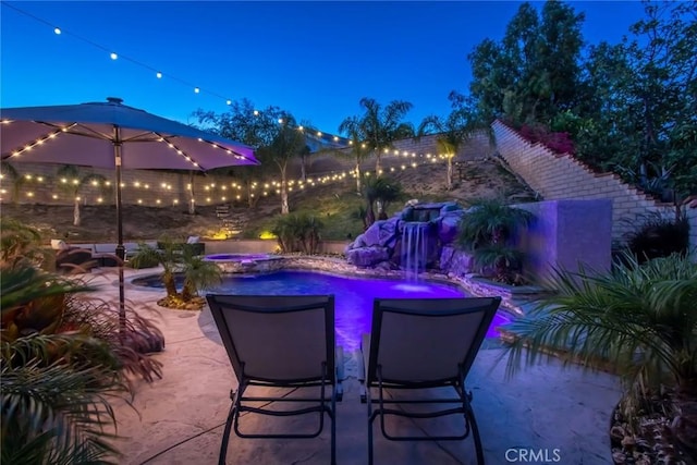 23235 Redbud Ridge Cir, Valencia, CA 91354 - patio at night featuring a patio area and a pool with connected hot tub