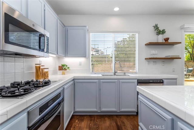 27960 Agapanthus Ln, Valencia, CA 91354 - kitchen featuring appliances with stainless steel finishes, tile countertops, recessed lighting, dark wood finished floors, and backsplash
