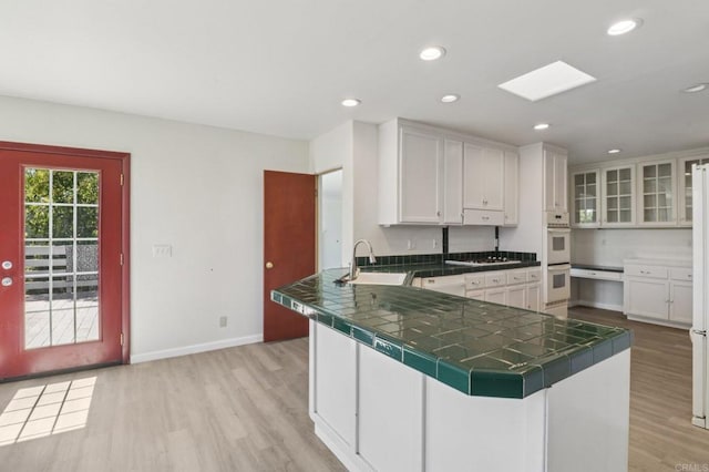 6737 San Miguel Ave, Lemon Grove, CA 91945 - kitchen with light wood-style flooring, white cabinetry, a peninsula, tile countertops, and recessed lighting