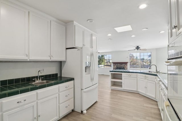 6737 San Miguel Ave, Lemon Grove, CA 91945 - kitchen featuring white appliances, white cabinets, recessed lighting, tile counters, and light wood-style flooring