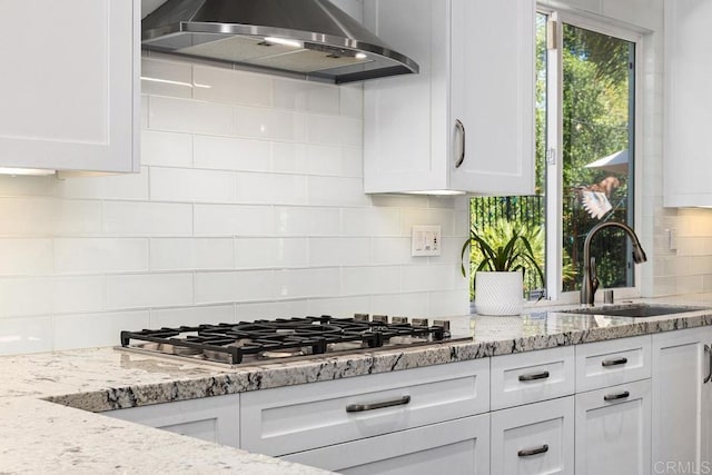 1467 Belmont Park Rd, Oceanside, CA 92057 - kitchen with wall chimney range hood, stainless steel gas stovetop, decorative backsplash, and white cabinetry