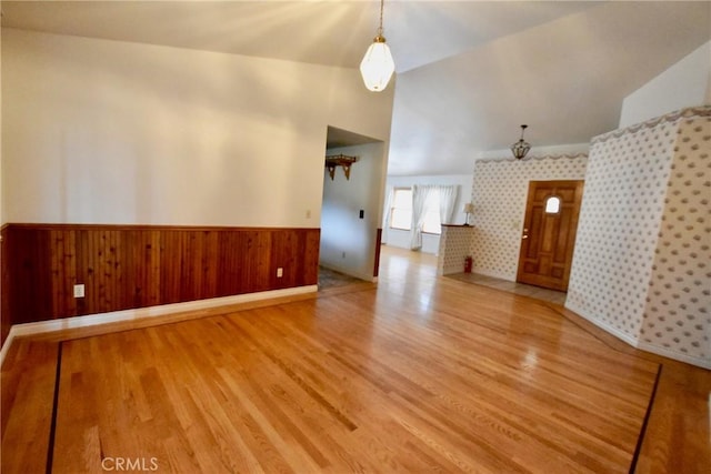 913 Northview Cir, Yreka, CA 96097 - unfurnished living room featuring wood finished floors, a wainscoted wall, vaulted ceiling, and wood walls