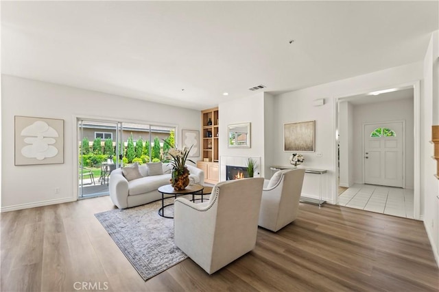 5255 La Madera Ave, El Monte, CA 91732 - living room with light wood-style flooring, a lit fireplace, and built in features